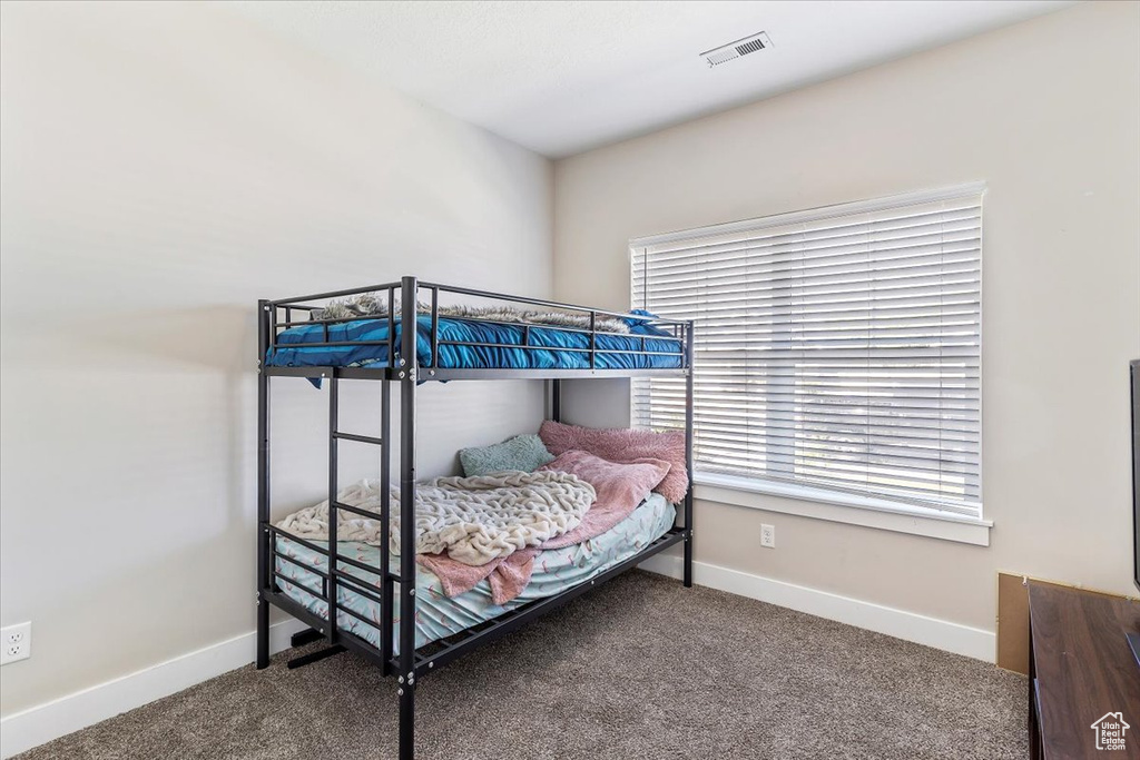 Bedroom featuring carpet and multiple windows