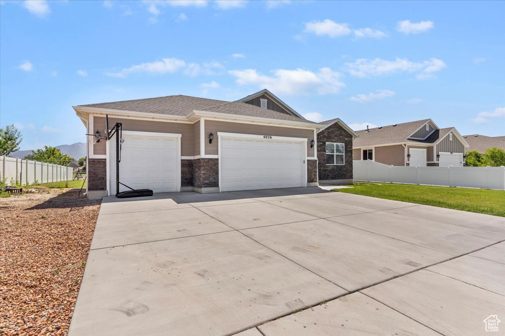 View of front facade featuring an attached garage and driveway