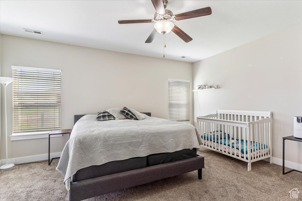 Carpeted bedroom with baseboards and a ceiling fan