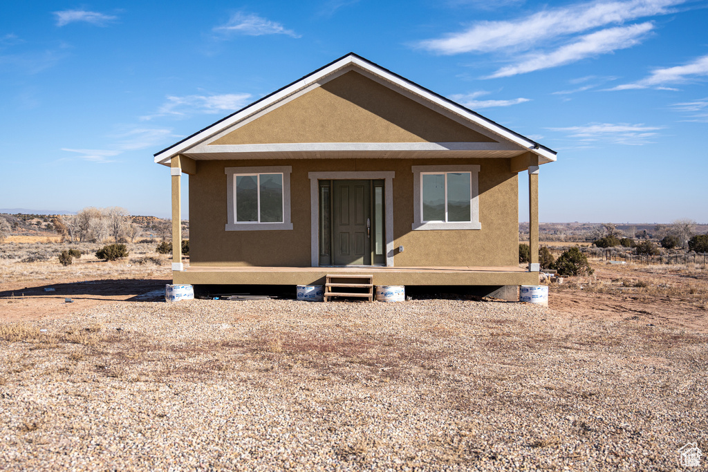 View of front facade with stucco siding and covered porch
