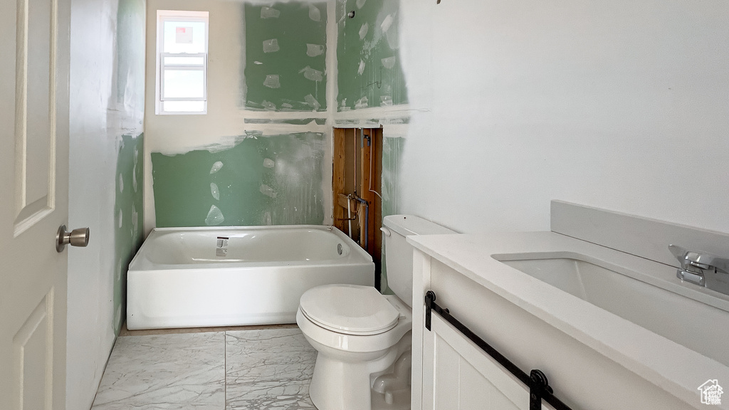 Full bathroom featuring a tub to relax in, marble finish flooring, and vanity