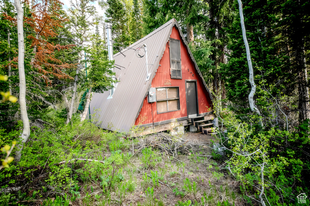 View of home's exterior with entry steps and a metal roof