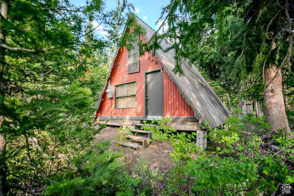 View of side of property featuring a metal roof and a garage