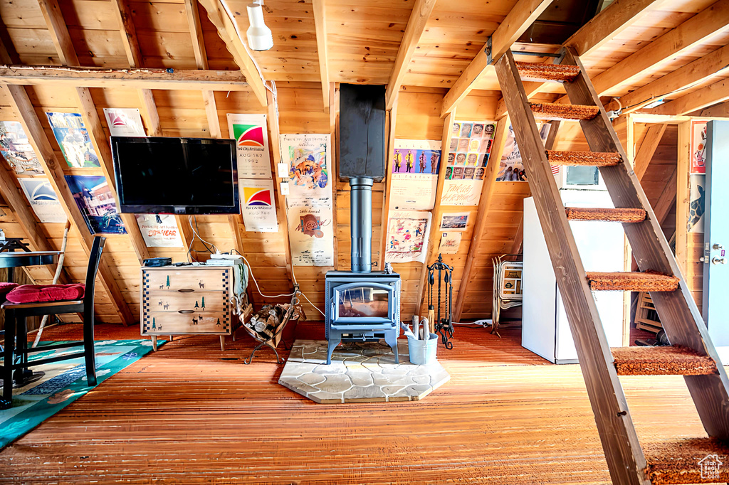 Living room featuring a wood stove, wood finished floors, and wood ceiling