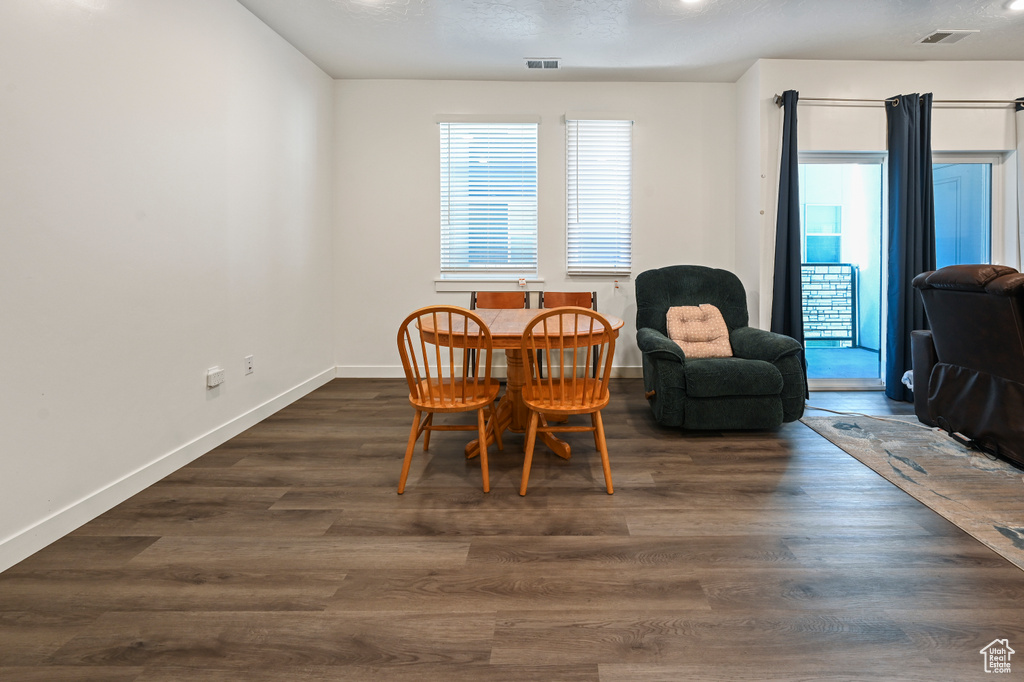 Dining room featuring dark wood-style floors and baseboards