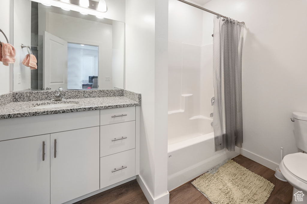 Full bath featuring wood finished floors, vanity, and shower / bathtub combination with curtain