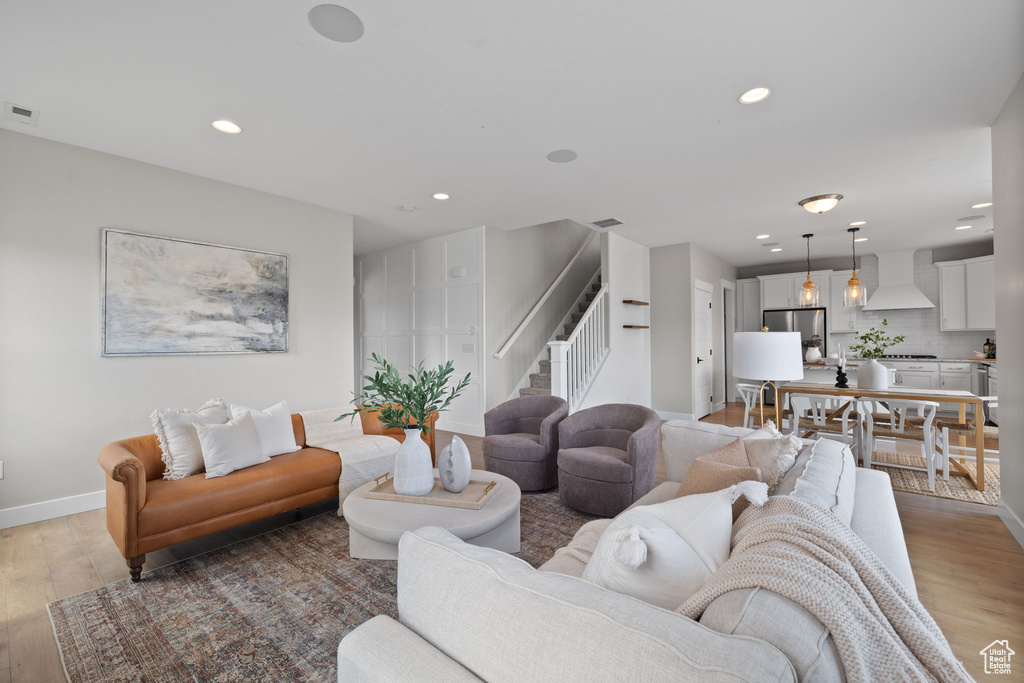 Living room featuring stairway, light wood finished floors, and recessed lighting