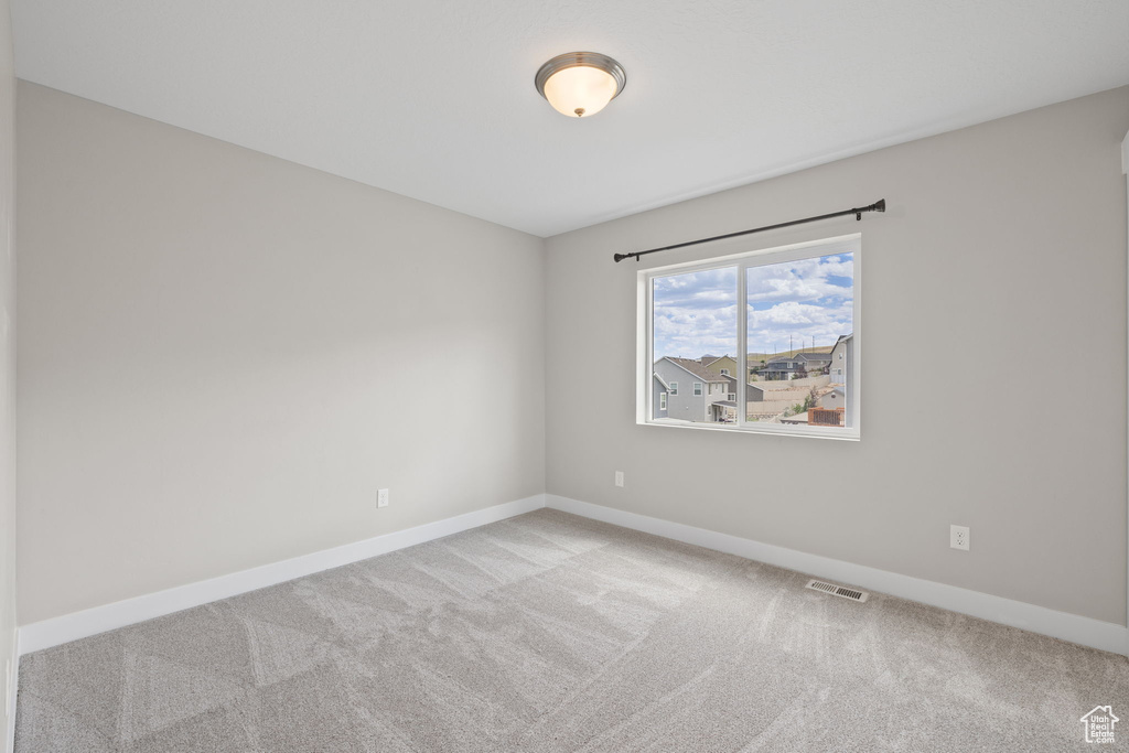 Carpeted spare room with baseboards