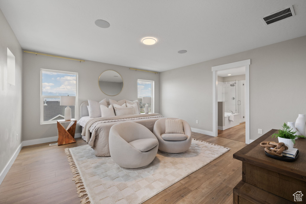 Bedroom with light wood-style floors and ensuite bathroom