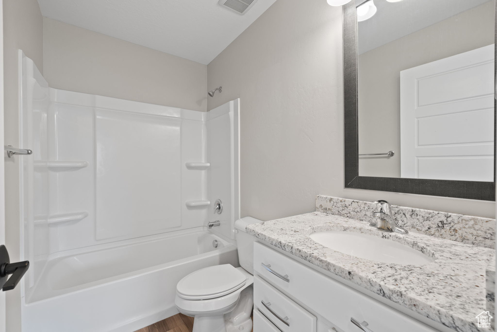 Full bath featuring vanity, bathtub / shower combination, and wood finished floors