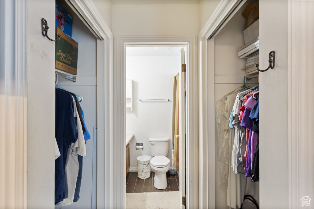 Full bathroom featuring wood finished floors, vanity, and a walk in closet