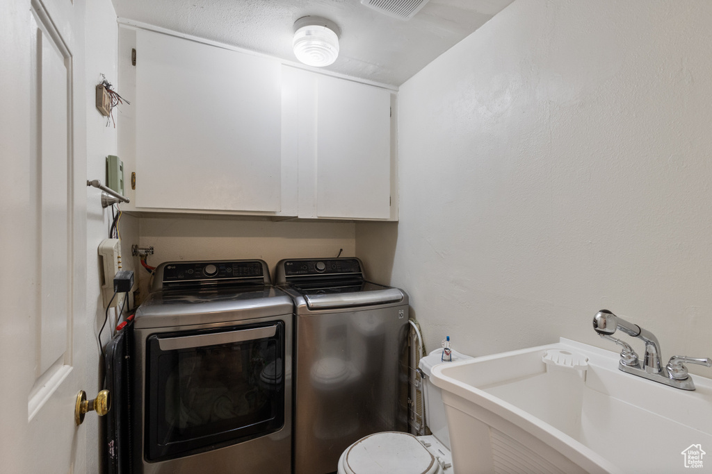 Laundry area featuring washing machine and dryer and cabinet space