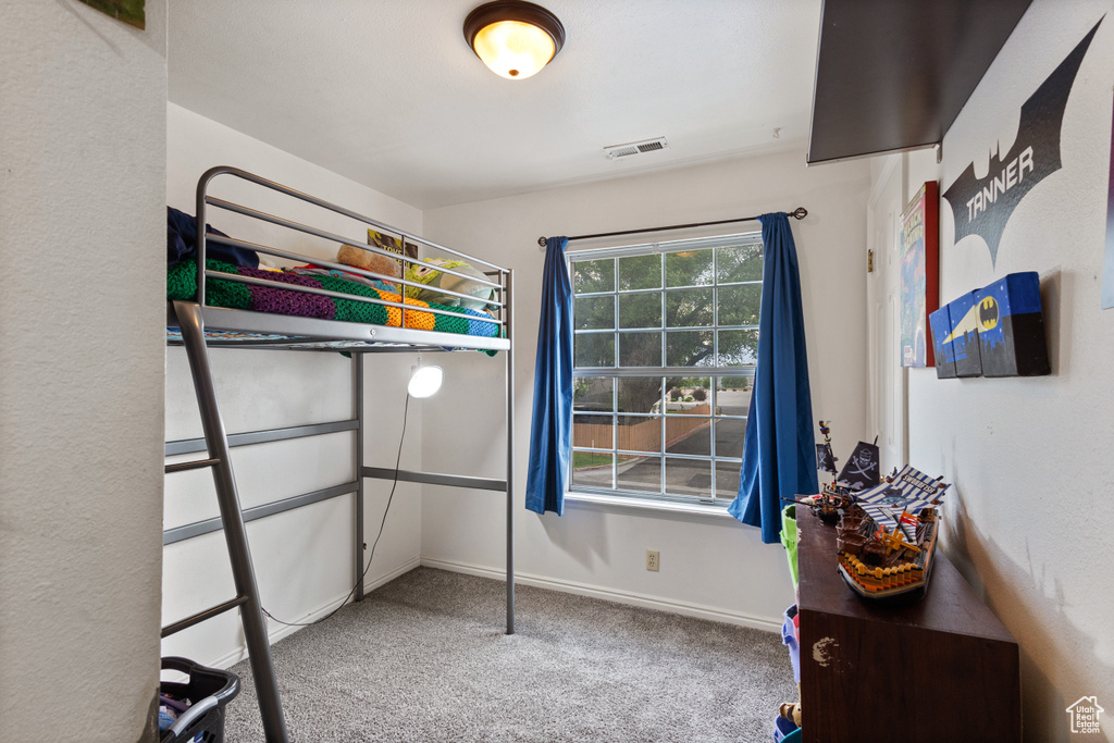 Bedroom featuring carpet and baseboards