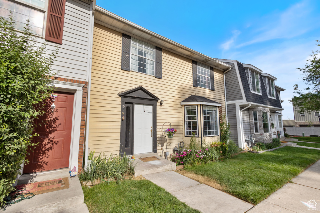 Townhome / multi-family property with a front lawn