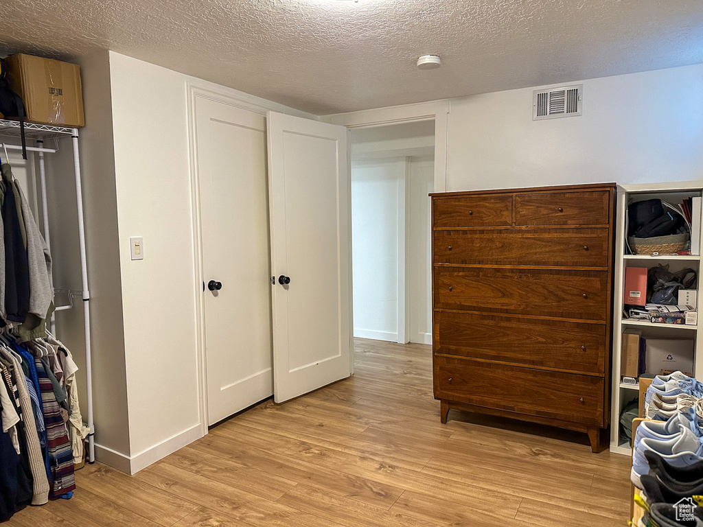 Bedroom featuring light wood-style floors and a textured ceiling