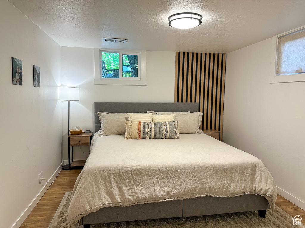 Bedroom featuring a textured ceiling and wood finished floors