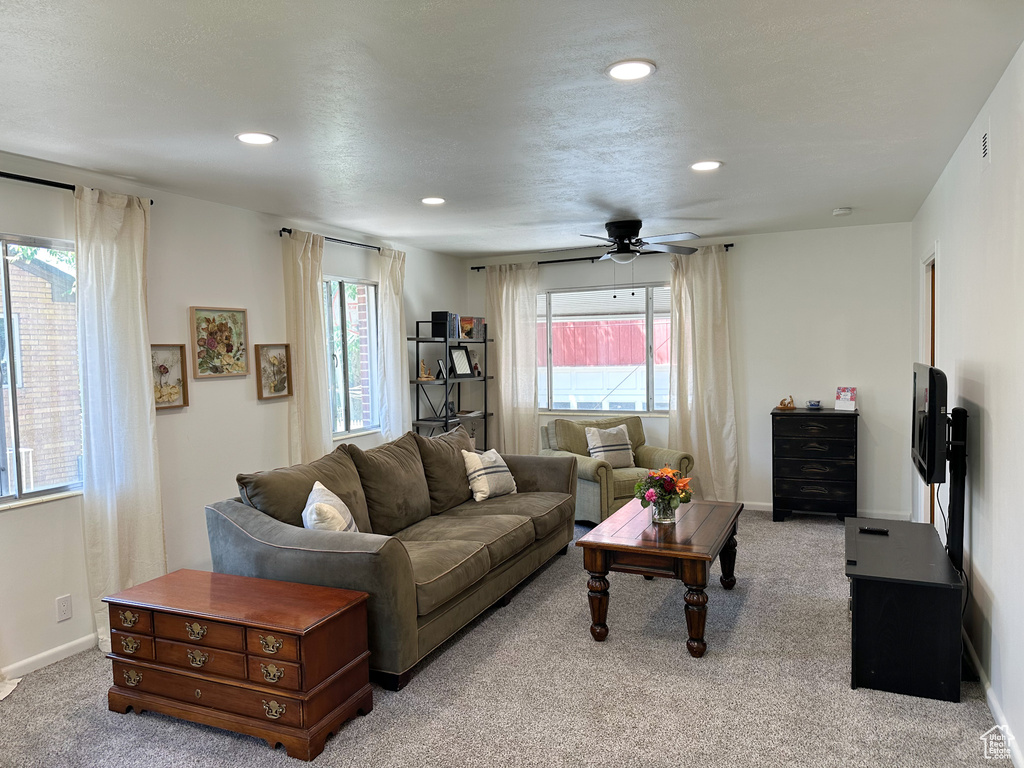 Living area with light carpet, ceiling fan, and recessed lighting