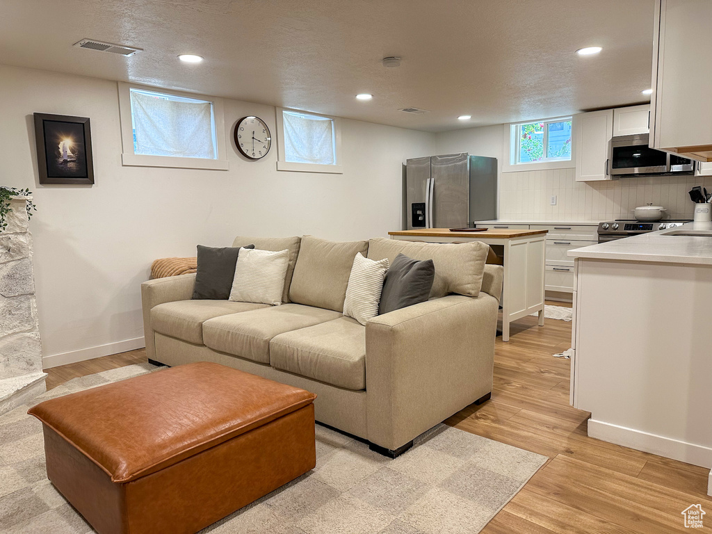 Living area with recessed lighting and light wood finished floors