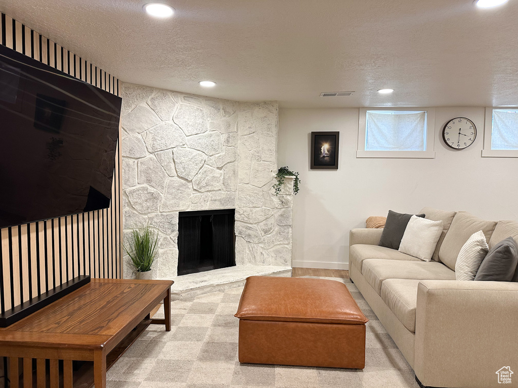 Living area with recessed lighting, a textured ceiling, a fireplace, and carpet flooring