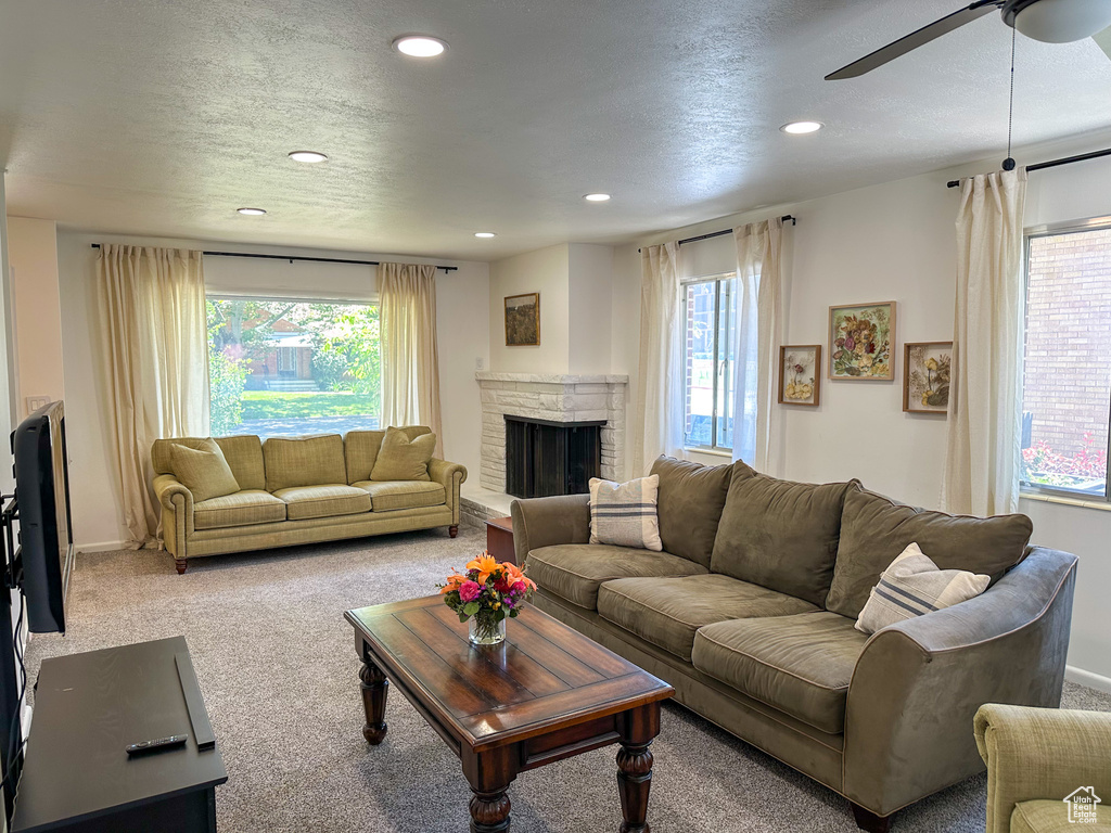 Living room featuring healthy amount of natural light, ceiling fan, recessed lighting, carpet flooring, and a fireplace