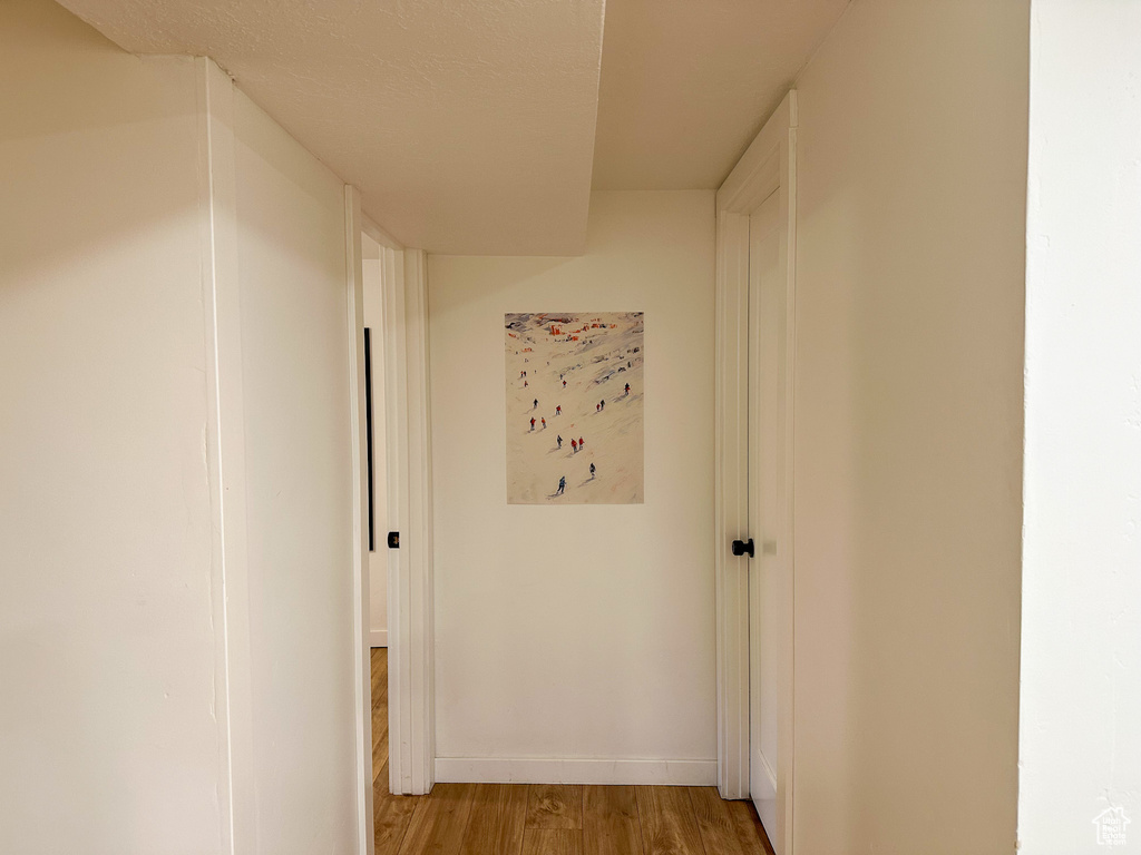 Corridor with light wood finished floors and baseboards