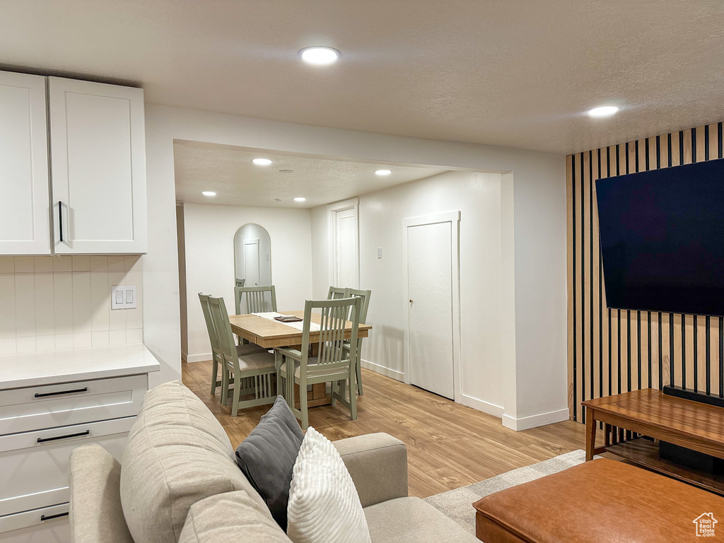 Living area with arched walkways, light wood-type flooring, and recessed lighting