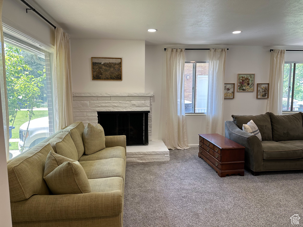 Carpeted living room with a fireplace and recessed lighting