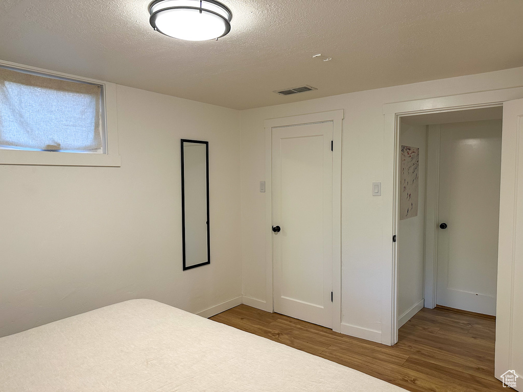 Unfurnished bedroom with wood finished floors and a textured ceiling