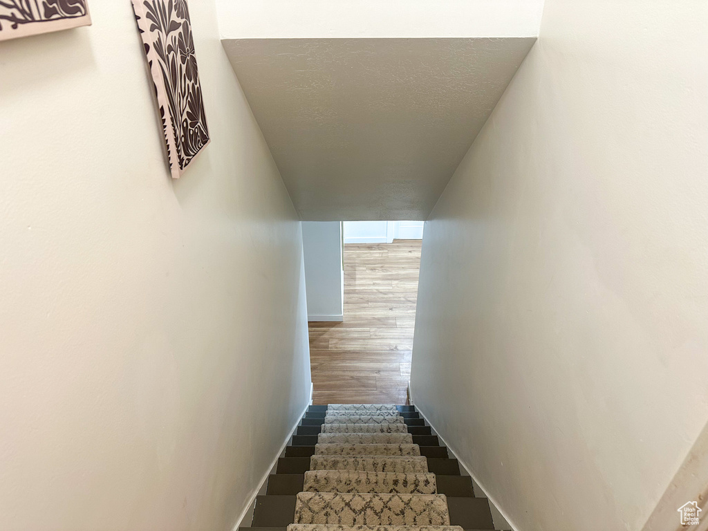 Stairway featuring wood finished floors and baseboards