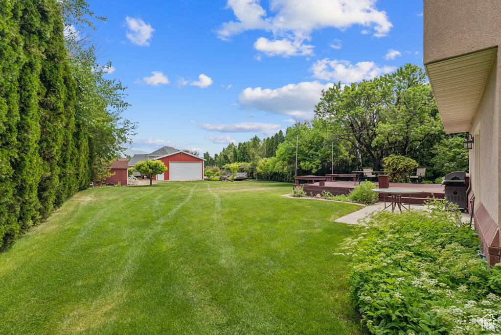 View of grassy yard with a garage