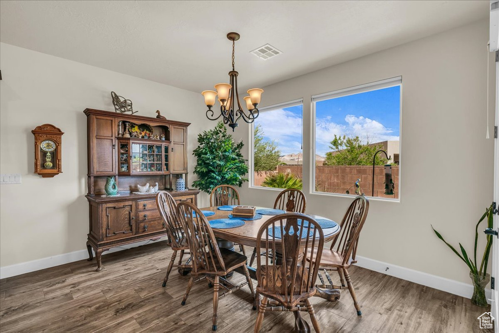 Dining space with a chandelier and wood finished floors