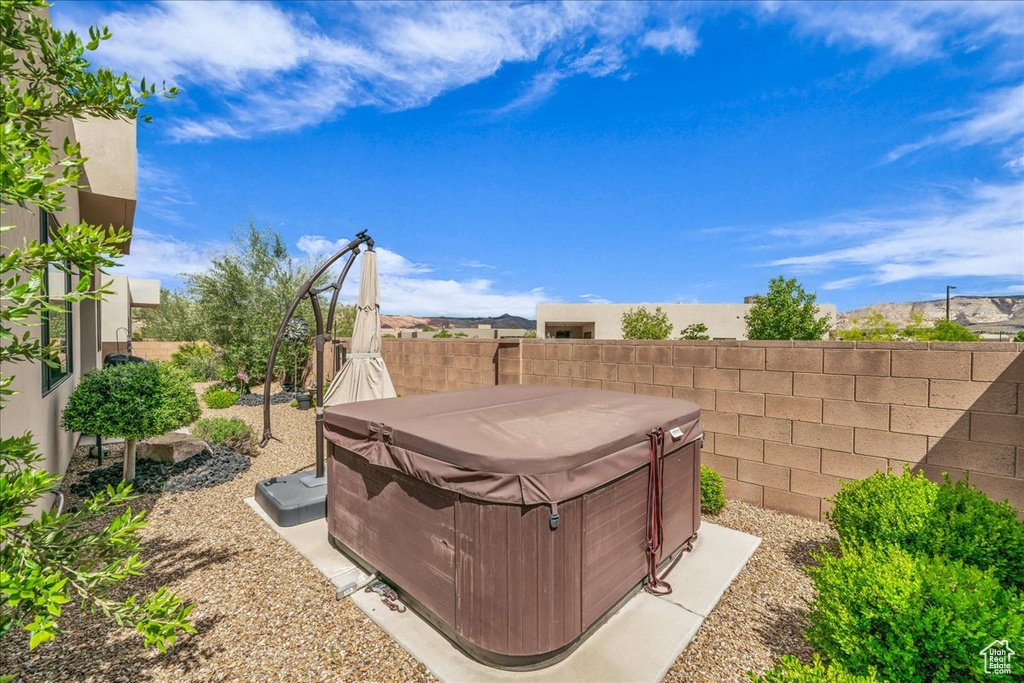 Fenced backyard with a hot tub