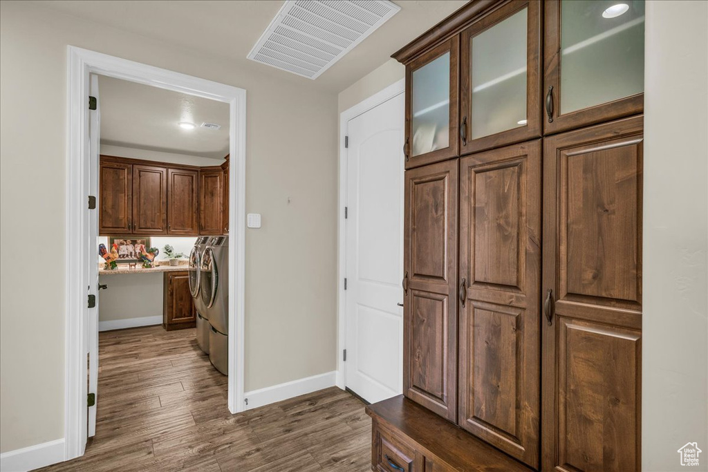 Hall with separate washer and dryer and dark wood-style flooring