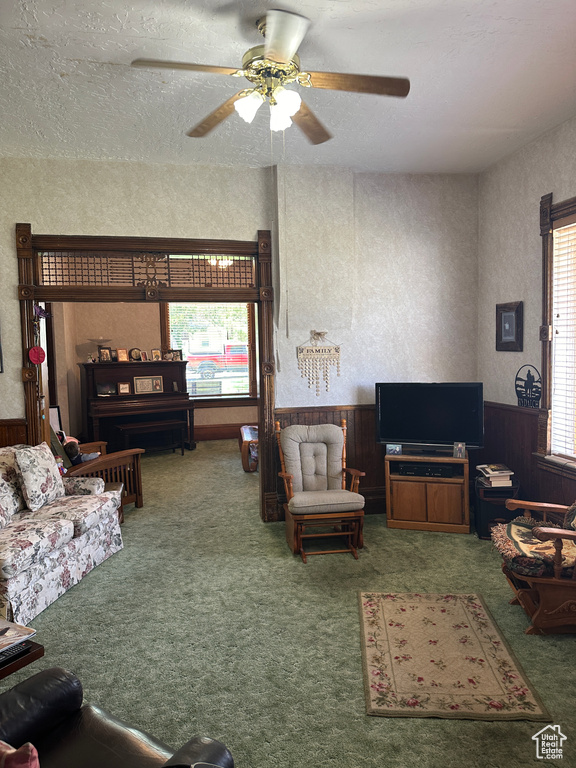 Carpeted living area with a ceiling fan