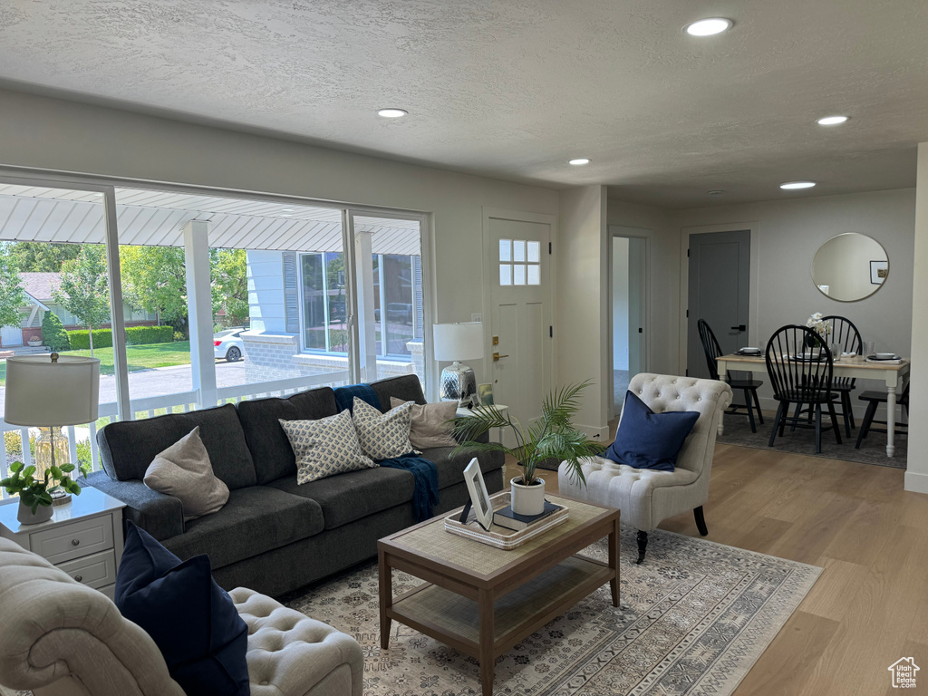 Living room with plenty of natural light, recessed lighting, light wood-style floors, and a textured ceiling