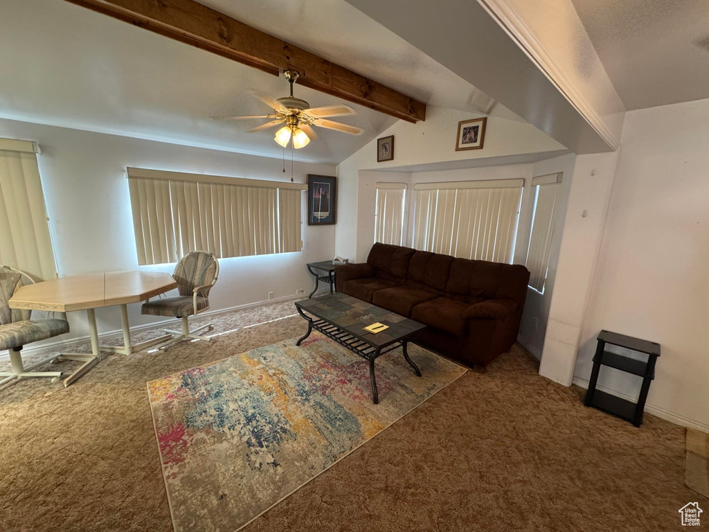 Carpeted living room with a ceiling fan and baseboards