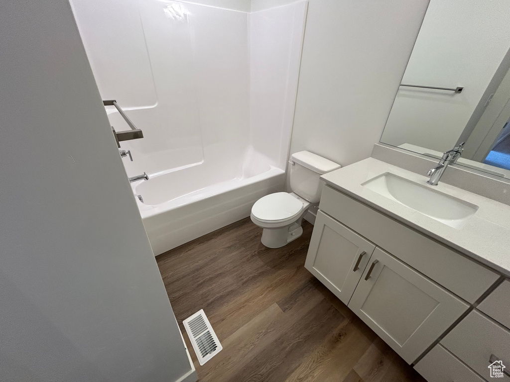 Full bath with wood finished floors, vanity, and tub / shower combination