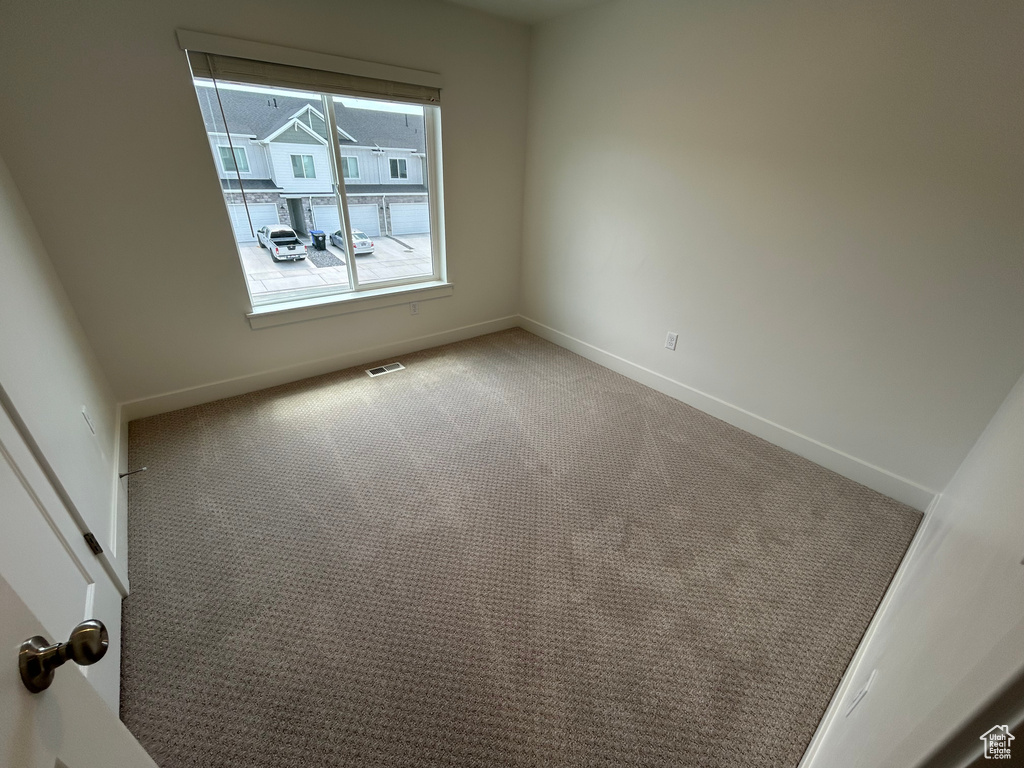 Carpeted empty room featuring baseboards