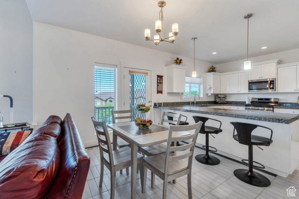 Dining area with a chandelier, recessed lighting, and light tile patterned flooring