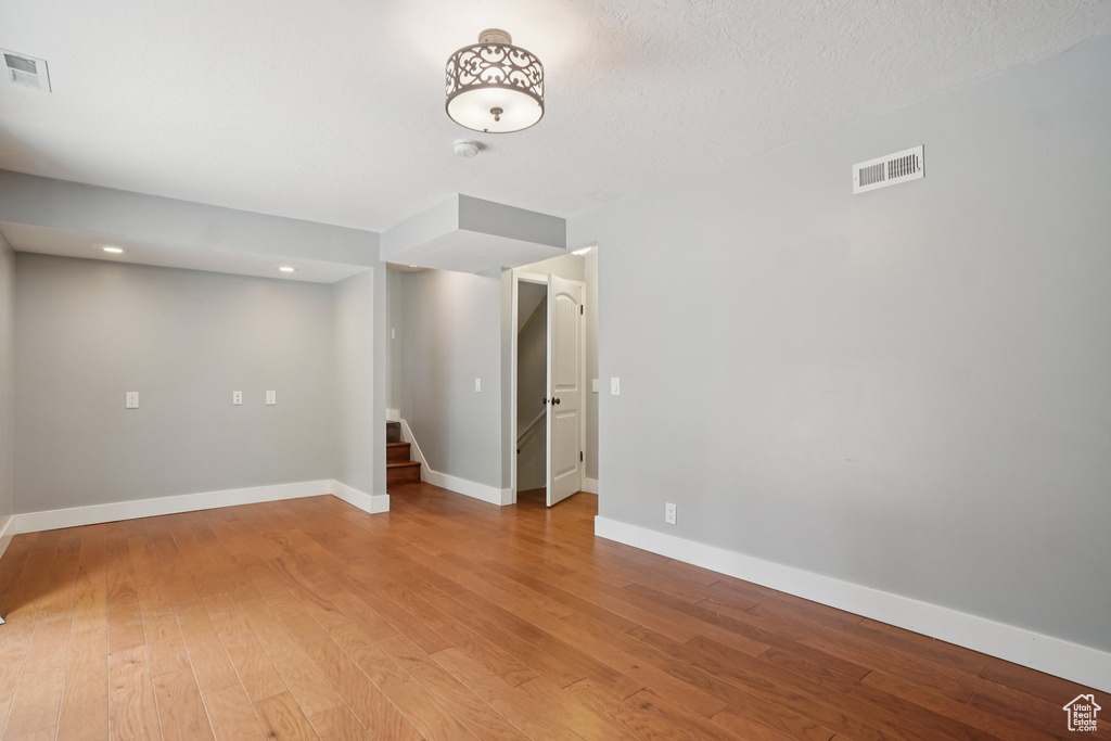 Unfurnished room featuring stairway, light wood finished floors, and recessed lighting