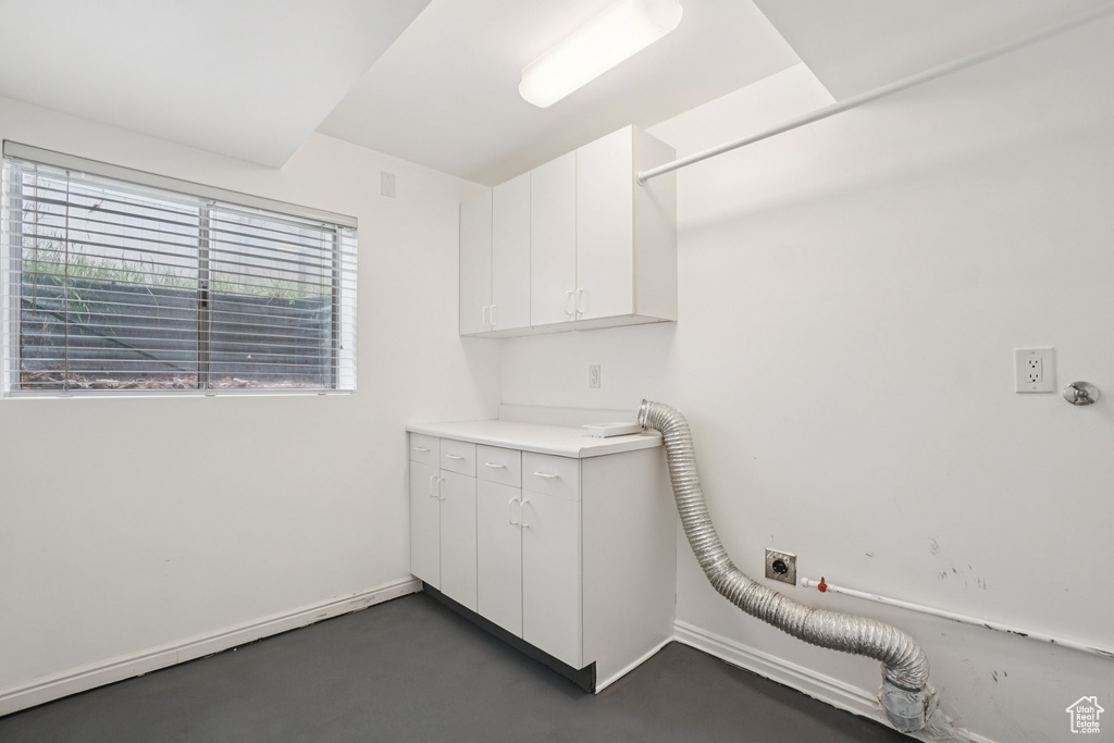 Washroom with hookup for an electric dryer, hookup for a gas dryer, and cabinet space