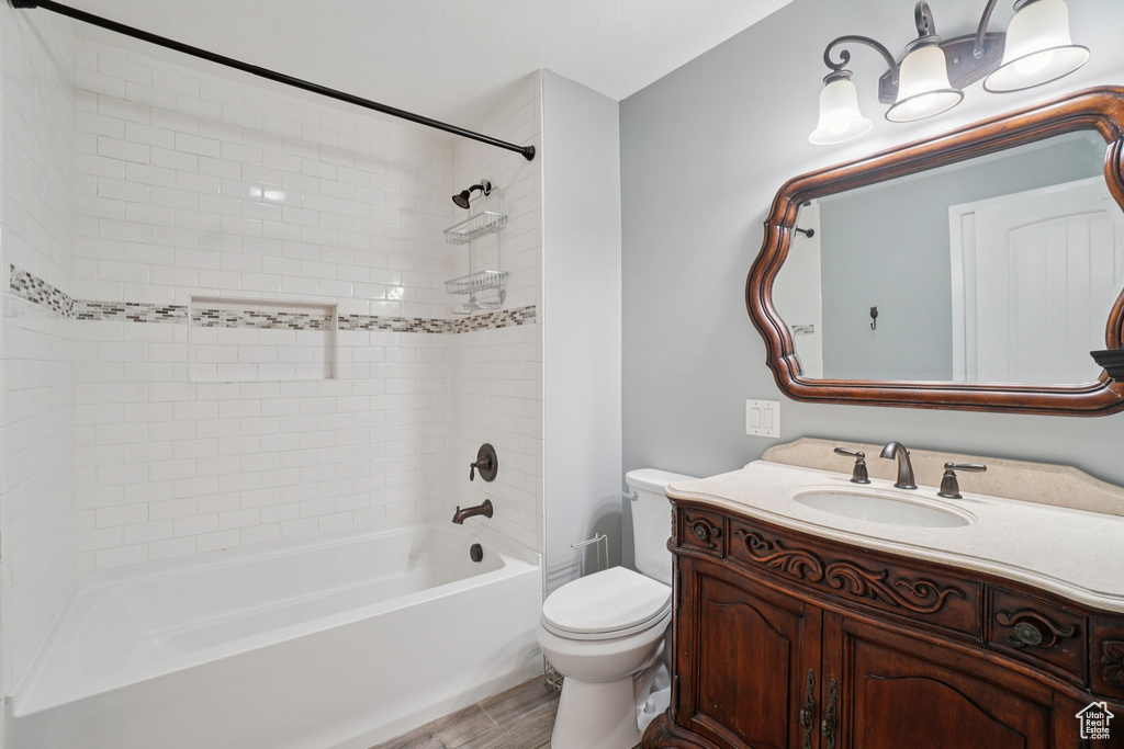 Full bath featuring vanity, shower / bath combination, and wood finished floors