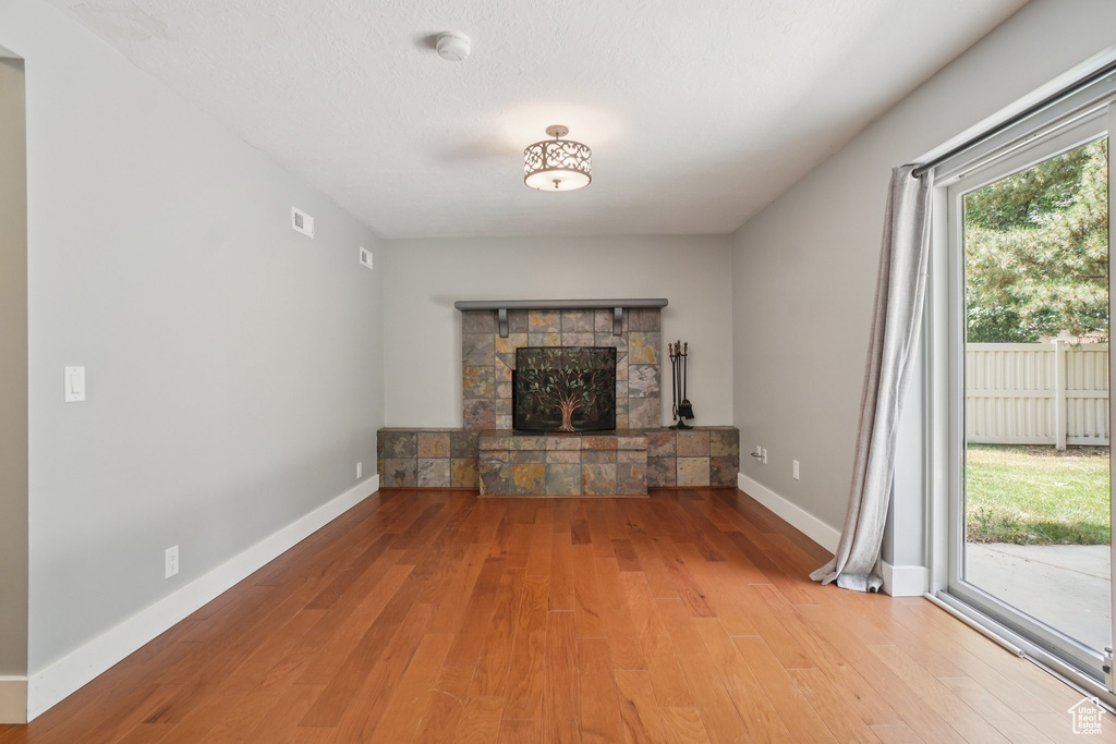 Unfurnished living room with wood finished floors and a fireplace
