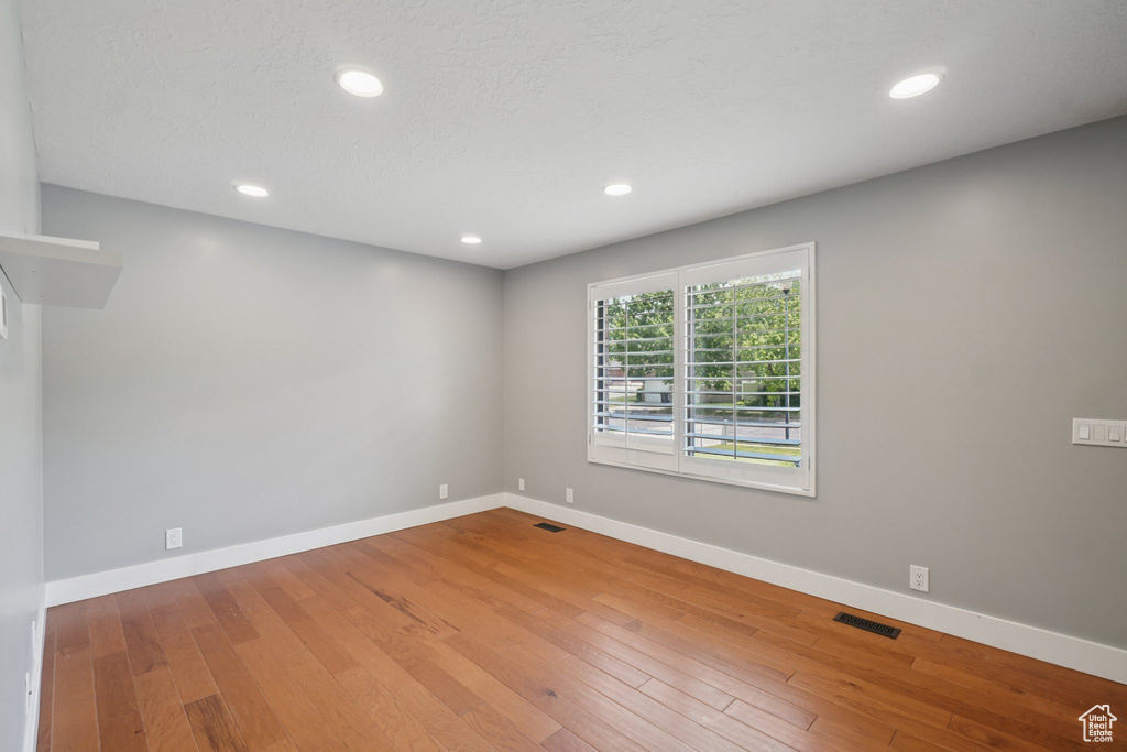 Empty room featuring wood-type flooring and recessed lighting