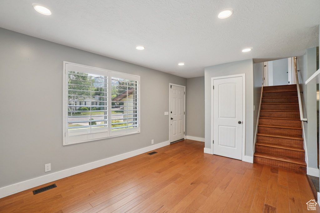 Foyer featuring light wood-style flooring, stairway, and recessed lighting