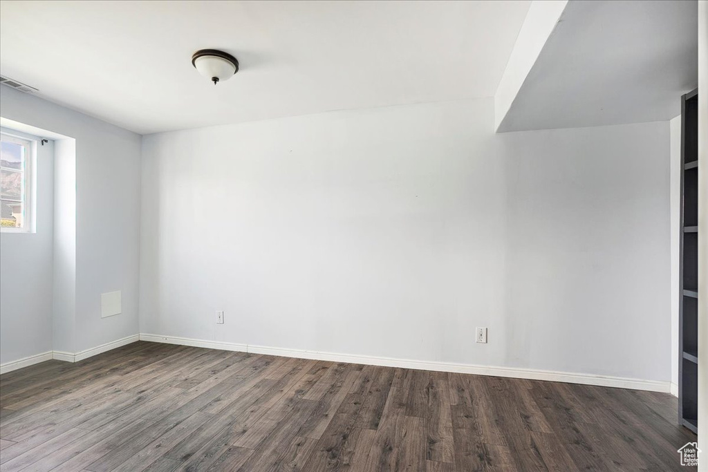 Spare room featuring dark wood-style floors