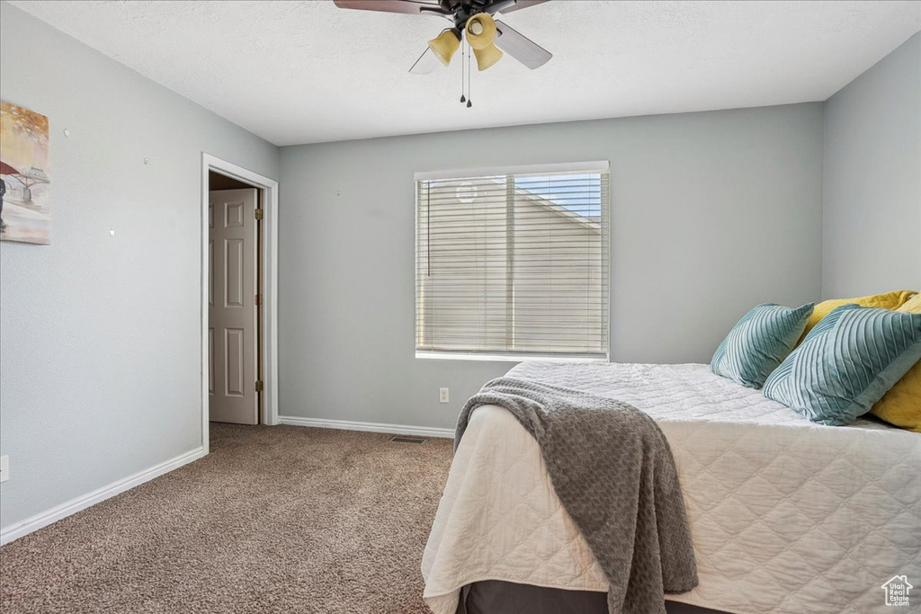 Carpeted bedroom with baseboards and ceiling fan