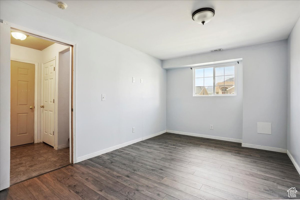 Spare room featuring a smoke detector and dark wood-style flooring