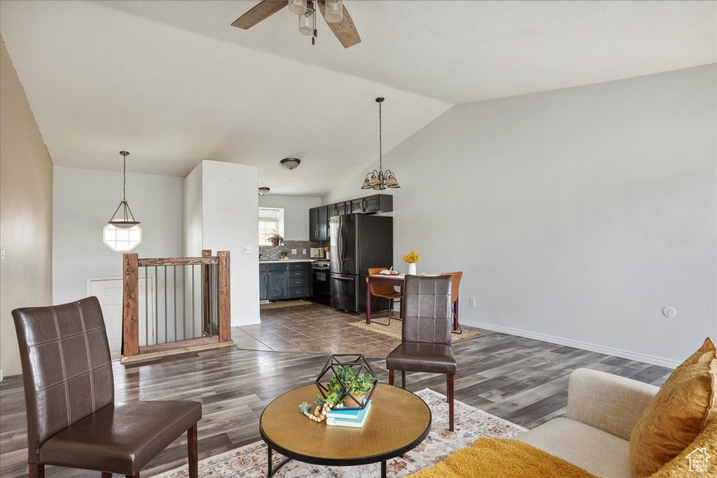 Living room with vaulted ceiling, a ceiling fan, and dark wood-style flooring