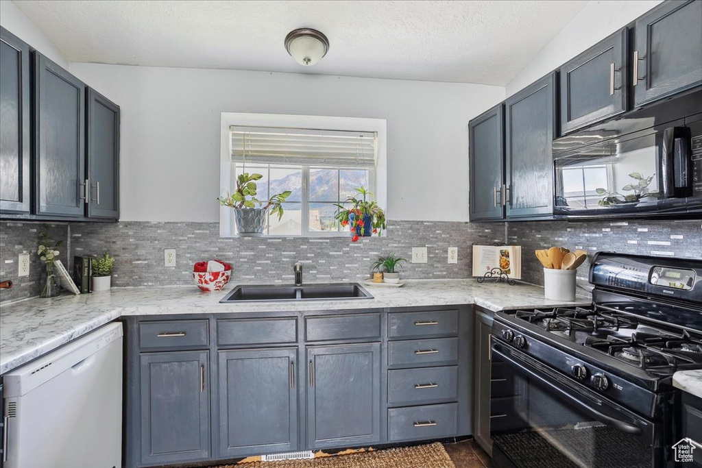 Kitchen with black appliances, plenty of natural light, and decorative backsplash